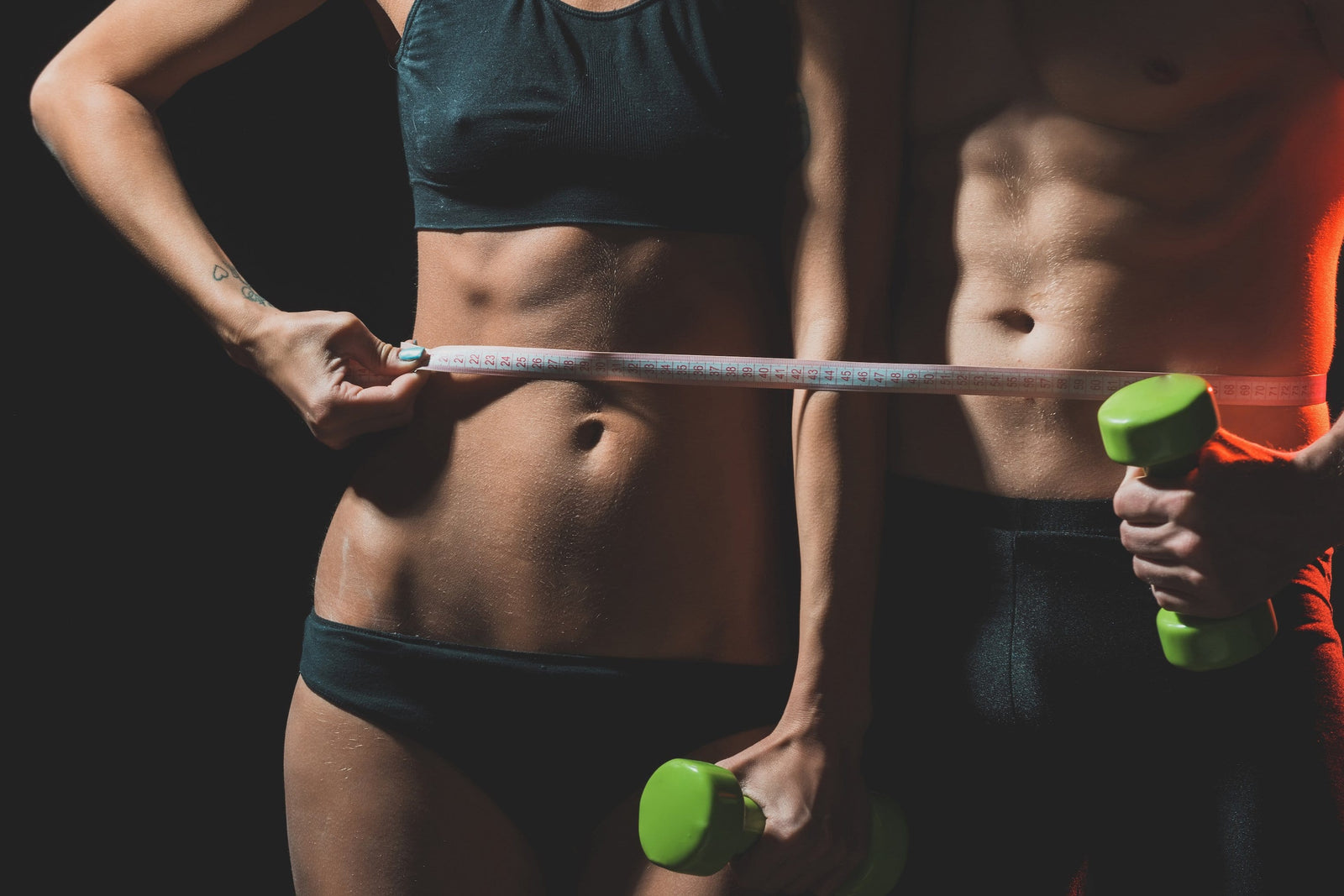 Athletic torso of a woman and a man getting measured