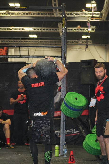 Back view from an athlete carrying a heavy ball