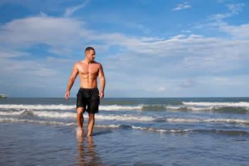 Athletic man just coming out of the water at the beach.