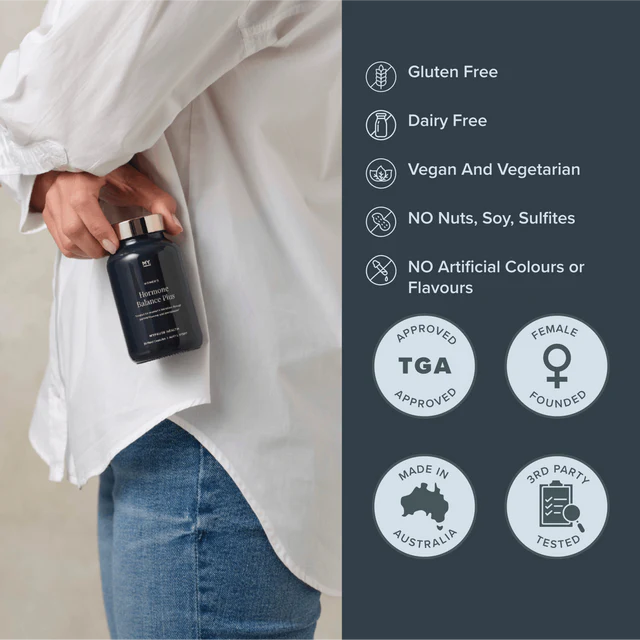 Person holding a black bottle with product details on a gray background